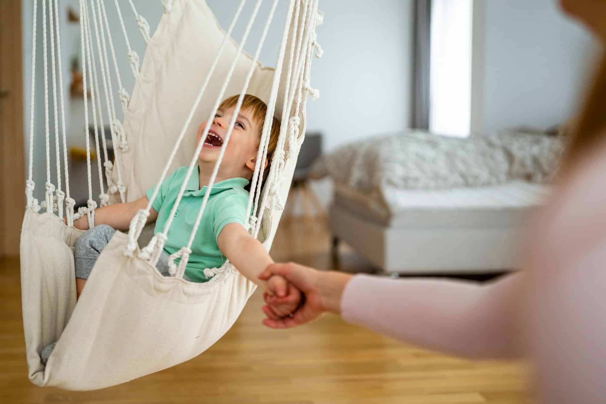 Beautiful woman and her little son having fun, playing at home.